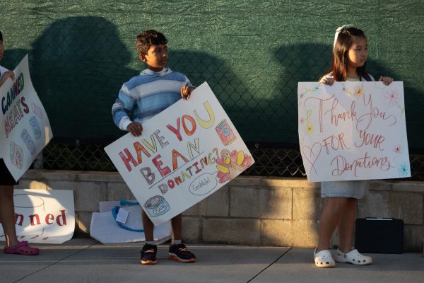 At the Lower School Autoline, ‘Iolani students hold up signs to inspire people to donate to the Thanksgiving Food Drive and thank those who have.